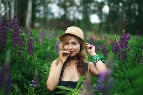 站在花草丛的性感戴帽美女图片